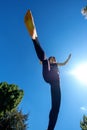 Sporty girl running in the sun and jumping over camera, view from below, copy space Royalty Free Stock Photo