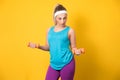 Sporty girl training biceps muscle with dumbbell, isolated on yellow background. Half length of fit sportswoman lifting weights.