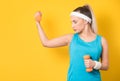 Sporty girl training gym with dumbbell, isolated on yellow background. Half length of fit sportswoman lifting weights. Fitness