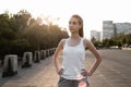 Sporty girl in white tank top standing with hands on hips. Royalty Free Stock Photo