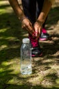 Sporty girl in the woods, tying the laces on sports shoes Royalty Free Stock Photo