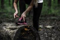 Sporty girl in the woods, tying the laces on sports shoes Royalty Free Stock Photo