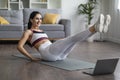 Sporty good-looking millennial woman exercising at home, watching fitness video Royalty Free Stock Photo