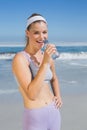 Sporty happy blonde drinking water on the beach Royalty Free Stock Photo