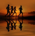 Sporty and healthy lifestyle, friends jogging at sunrise on summer beach. Silhouette of group of people running on sunny beach.