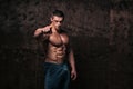 Sporty and healthy muscular man on dark grunge background Royalty Free Stock Photo