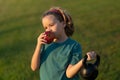 Sporty kid with apple and kettlebell outdoor in summer park. Kids sports exercises. Healthy kids life and sport concept