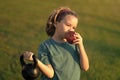 Sporty kid with apple and kettlebell outdoor in summer park. Kids sports exercises. Healthy kids life and sport concept