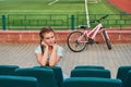 A young bright girl loves sports.The girl in the blue seats of the stadium. Royalty Free Stock Photo