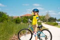 Sporty kid riding bike on a park. Child in safety helmet riding bicycle. Kid learns to ride a bike. Kids on bicycle Royalty Free Stock Photo