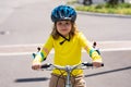 Sporty kid riding bike on a park. Child in safety helmet riding bicycle. Kid learns to ride a bike. Kids on bicycle Royalty Free Stock Photo