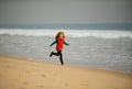 Sporty kid running in nature. Child running through water close to shore along the sea beach. Little runner exercising Royalty Free Stock Photo