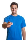 Sporty latin guy in a blue shirt pointing at camera Royalty Free Stock Photo