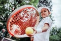 Sporty little girl preparing to serve tennis ball. Close up of beautiful yong girl holding tennis ball and racket. Child tennis