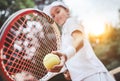 Sporty little girl preparing to serve tennis ball. Close up of beautiful yong girl holding tennis ball and racket. Child tennis Royalty Free Stock Photo