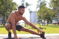 Sporty man doing workout stretching exercises for legs outdoors Royalty Free Stock Photo