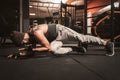 A sporty man in the gym is doing Yoga exercises. Push up alternative exercises. Plank with Knee to Elbow Exercise. Royalty Free Stock Photo