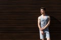Sporty man leaning on wooden wall, copy space Royalty Free Stock Photo