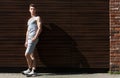 Sporty man leaning on wooden wall, copy space Royalty Free Stock Photo