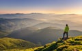 Sporty man on the mountain peak looking on mountain valley Royalty Free Stock Photo