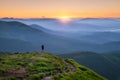 Sporty man on the mountain peak looking on mountain valley Royalty Free Stock Photo