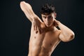 sporty man with muscular muscle body posing against dark background cropped view