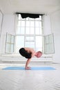 Sporty man practicing yoga. Handstand Urdhva Kukkutasana. Upward