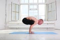 Sporty man practicing yoga. Handstand Urdhva Kukkutasana. Upward