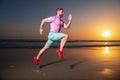 Sporty man runner running in summer sea beach. Attractive fit man run on sunset light, workout outdoors, jogging with Royalty Free Stock Photo