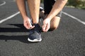 Sporty man tying shoelaces outdoors on sunny morning, closeup Royalty Free Stock Photo