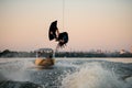 Sporty man wakeboarder skilfully jumps and flips on wakeboard over splashing wave Royalty Free Stock Photo