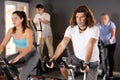 Sporty man working out on stationary bicycle in gym Royalty Free Stock Photo
