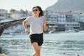 Sporty mature woman jogging running at seaside promenade Royalty Free Stock Photo