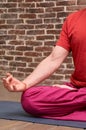 Sporty mindful man meditating alone on red brick wall background Royalty Free Stock Photo