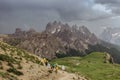 Sporty people in raincoats hiking in Dolomites,Italy.Rainy day outdoors. View of mountain landscape with dark moody Royalty Free Stock Photo