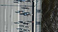 Sporty people run summer marathon along huge grey bridge