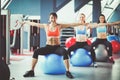 Sporty people sitting on exercise mats at a bright fitness studio. Sporty girls Royalty Free Stock Photo