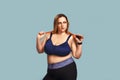 Sporty plus size woman. Confident young plump woman holding a jumping rope at her shoulders and looking at camera while Royalty Free Stock Photo