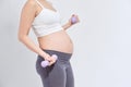 Sporty pregnant woman exercising with dumbbells