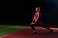 Sporty girl training on stadium at night after running. Royalty Free Stock Photo