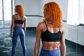 Sporty redhead girl have fitness day in gym at daytime. Muscular body type Royalty Free Stock Photo