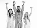 Sporty regime concept. Man in robe, trainer holds clock, attractive young women in pajamas doing exercises with