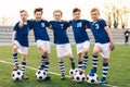 Sporty School Boys in Soccer Team. Group of Children in Football Jersey Sportswear Standing with Balls on Grass Pitch Royalty Free Stock Photo