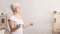 Sporty senior woman exercising with dumbbells at home Royalty Free Stock Photo