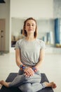 Sporty woman sitting cross-legged in lotus pose in bright room Royalty Free Stock Photo