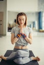 Sporty woman sitting cross-legged in lotus pose in bright room Royalty Free Stock Photo