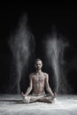 Sporty serene young man meditating sitting in cross-legged yoga lotus pose, Padmasana with palms in mudra Royalty Free Stock Photo