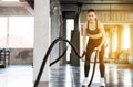 Sporty and slim asian woman using battle rope at gym,Female doing exercise in functional trainin Royalty Free Stock Photo