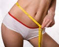 Sporty, slim woman with measuring tape on belly Royalty Free Stock Photo