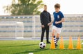 Sporty Soccer Boys Running Ball on Training Drill. Young Coach Watching Youth Football Team Practice Session